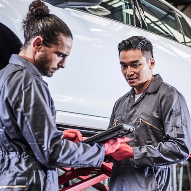 man in workshop infront of a car with brake booster 