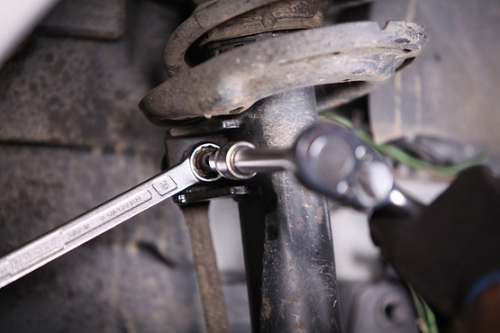 Desserrer l'écrou de fixation sur la jambe de suspension et l'enlever.